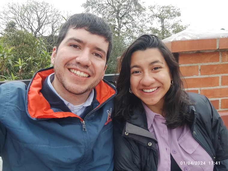 La pareja sonriendo al aire libre.