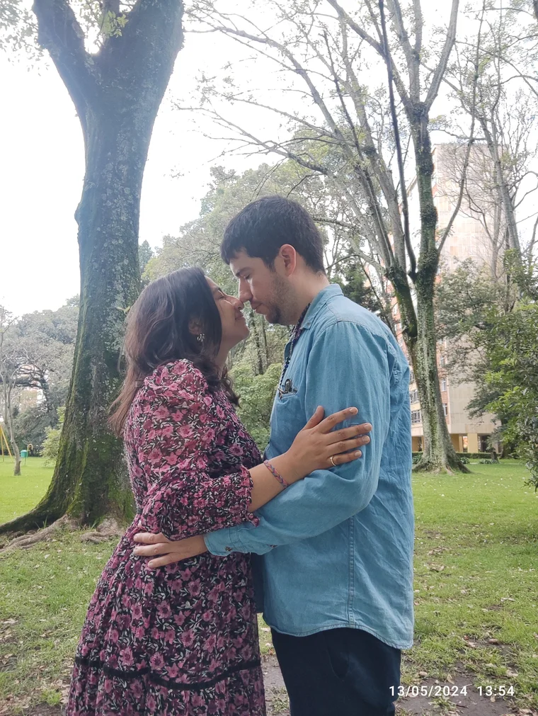 La pareja frente a frente en un jardín.