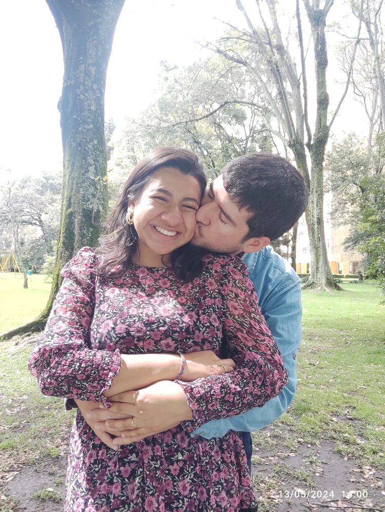 La pareja compartiendo un momento afectuoso en un parque.