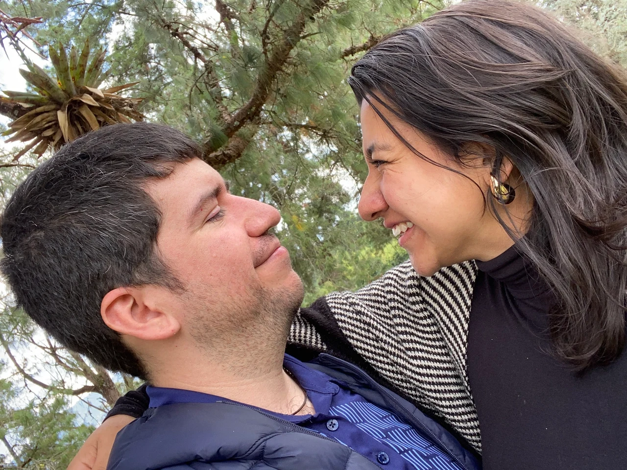 La pareja sonriendo junta al aire libre.